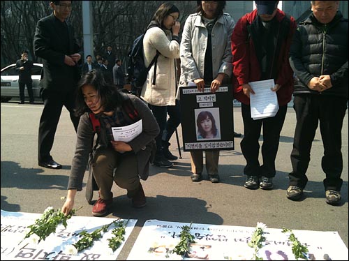 반올림 회원이 고 박지연씨의 영정사진 앞에 헌화하고 있다.