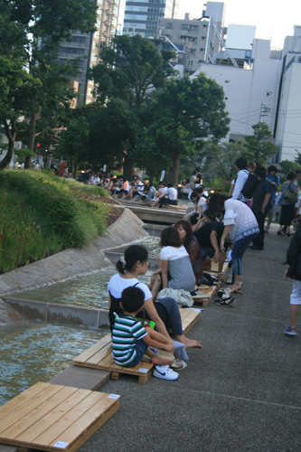 시민들이 흐르는 냇물에 발을 담그고 편안히 쉬고 있다.
