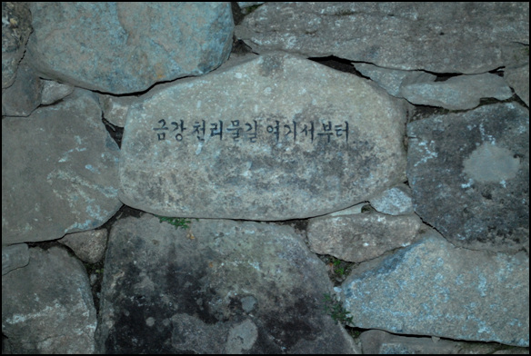 돌로 쌓은 샘의 돌에 '천리 물길 여기서부터'라는 글이 보인다 