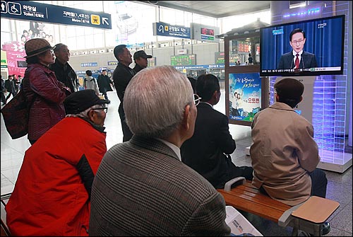 시민들이 1일 오전 서울역 대합실에 설치된 TV 모니터를 통해 이명박 대통령의 신공항 백지화 관련 기자회견을 지켜보고 있다.

