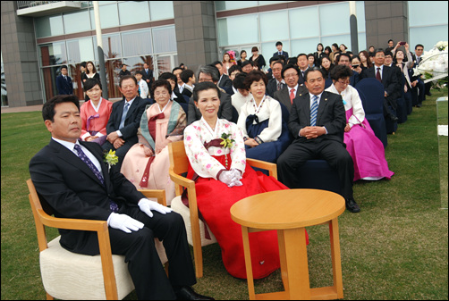 신부의 가족들이 결혼식이 진행되는 과정을 즐거운 표정으로 바라보고 있다.
