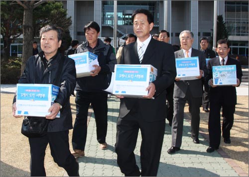 '과학벨트 대선공약이행 대전비상대책위원회' 대표들이 100만 대전시민 서명지를 청와대에 전달하기 위해 버스에 싣고 있다.