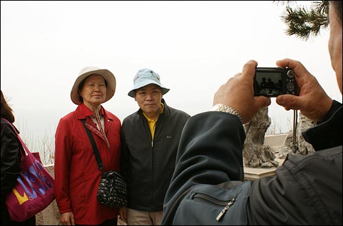위창복(62)씨, 이양순(61)씨 부부가 중국 청도 소어산 정상에서 기념 사진을 촬영하고 있다.