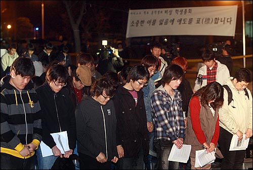 13일 저녁 대전 유성구 카이스트 행정관 앞에서 열린 비상총회에서 학생들이 자살한 학생들과 교수를 추모하며 묵념을 하고 있다. 