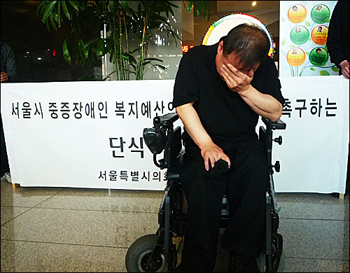 13일 오후 서울 중구 서소문동 다산플라자 로비에서 장애인 복지예산 집행을 촉구하며 108배를 마친 후 이상호 의원이 눈물을 흘리고 있다.