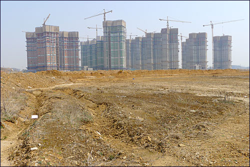 13일 오후 인천 중구 중산동 영종하늘도시에서 아파트 건설 공사가 한창이다. 하지만 그 주변 상업용지는 분양이 이뤄지지 않으면서 황무지로 남아있다.