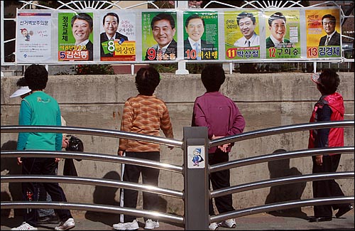 4.27 재보선을 열흘 앞둔 17일 오후 전남 순천시 연향중학교 앞에서 시민들이 국회의원 보궐선거 벽보를 살펴보고 있다.