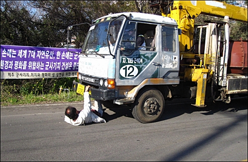  고권일 해군기지반대주민대책위 공동위원장이 공사장으로 들어가는 트럭을 막고 있다.