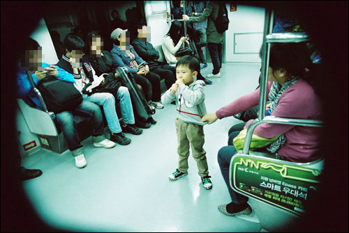 어린이들은 지하철 안에서 마땅히 잡을 곳 없이 서 있을 수밖에 없다. 끝 좌석의 봉이 있지만 출입구 주변이라 부모들은 걱정을 떨쳐 낼 수 없다