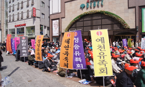 한국전쟁전후 민간인피학살자 전국유족회 회원들이 지역유족회 깃발을 들고 있다.