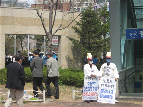  한진중노조원 뒤편에 한나라당 선거운동원이 보인다