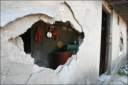 주민이 살고 있는 집 벽을 철거반원들이 부숴서 큰 구멍이 생겼다.