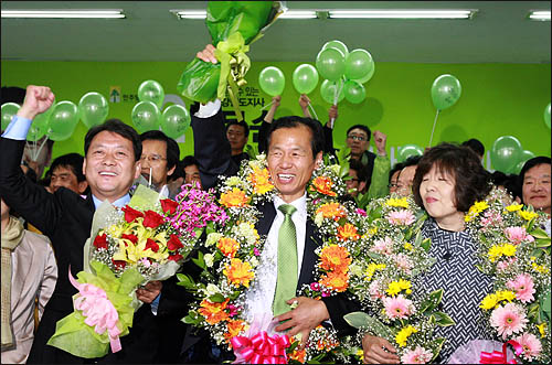  4.27 재보선 개표결과 최문순 민주당 후보가 강원도지사 당선이 확정되자 최 후보가 이광재 전 강원도지사의 손을 맞잡고 지지자들의 환호에 답하고 있다.