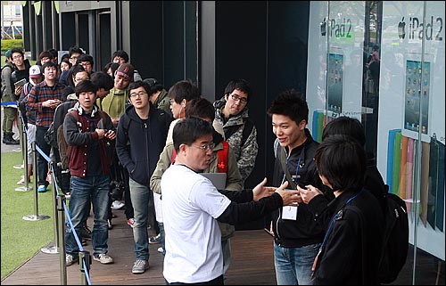 애플의 아이패드2가 국내 출시된 29일 오전 서울 광화문 KT사옥 올레스퀘어에서 예약가입자들이 아이패드2를 구매하기 위해 줄을 서서 기다리고 있다.