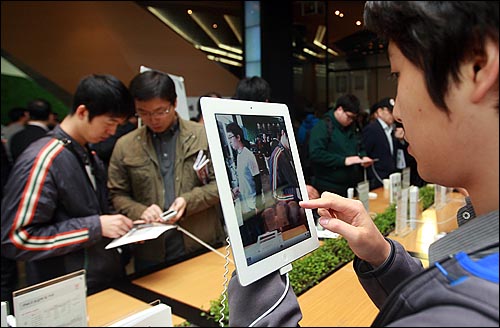 애플 아이패드2가 국내 출시된 지난해 4월 29일 오전 서울 광화문 KT사옥 올레스퀘어에서 예약가입자들과 시민들이 아이패드2를 만져보고 있다.