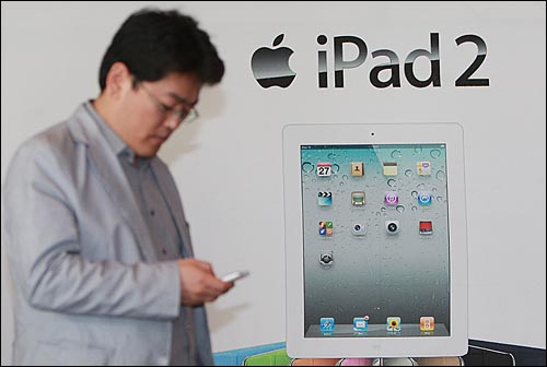 애플의 아이패드2가 국내 출시된 29일 오전 서울 광화문 KT사옥 올레스퀘어에서 한 시민이 아이패드2 광고판 앞을 지나가고 있다.