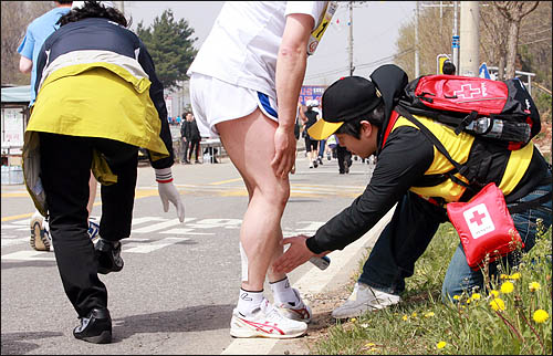  1일 인천시 강화군에서 열린 '2011 강화 바다사랑 오마이뉴스 마라톤대회'에 자원봉사자로 나선 대한적십자사 소속 응급처치 강사들이 대회 참가자들의 통증을 치료해주고 있다.