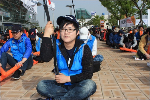 노동절 집회에 참석한 한 젊은 조합원이 깃발을 들고 있다.