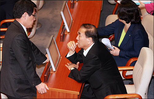 4일 오후 국회 본회의장에 도착한 이재오 특임장관이 한나라당 이군현 원내수석부대표를 불러 상황을 보고받고 있다.