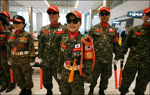 박근혜 의원 팬클럽인 '박근혜 사랑하는 해병들 모임(박해모)' 회원들이 군복을 입고 야광봉을 든 채 입국장에 도열해 있다.