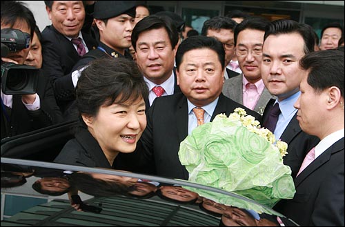 인천공항 귀빈실에서 간단한 간담회를 마친 박근혜 의원이 친박계 의원들과 지지자들에게 둘러싸여 승용차에 올라타고 있다.