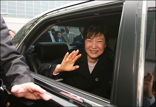 승용차를 타고 떠나며 박근혜 의원이 지지자들에게 손을 흔들고 있다.