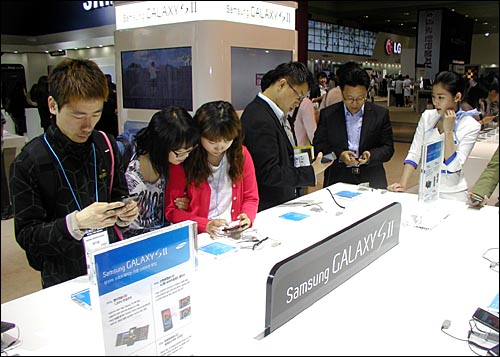 지난해 5월 코엑스에서 열린 월드IT쇼에 스마트폰들을 살펴보고 있는 참관객들 