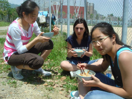 　봉사활동으로 비빔밥을 만든 가나디안아카데미 9 학년 학생들이 밥을 먹고 있습니다. 왼쪽부터 윤현경, 로자 나타샤, 박은별입니다.