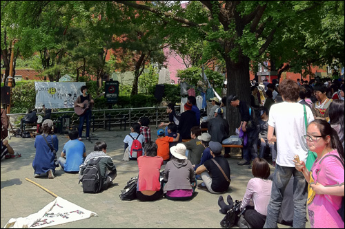 서울 대학로 마로니에공원에서 공연하는 가수 '시와'와 구경하는 시민들.