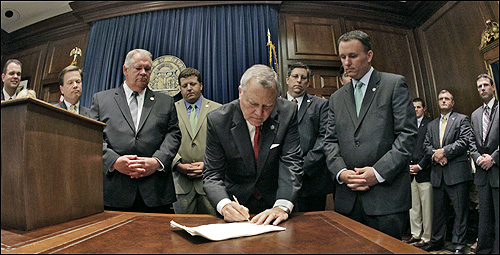 조지아 주의 네이튼 딜 주지사가 반이민법에 서명하고 있다. 오른쪽에 서 있는 사람이 법안 발의자인 공화당의 매트 램지 의원. 정치 신인이던 매트 램지 의원은 이번 법안으로 하루아침에 스타가 되었다.