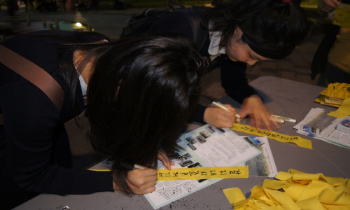 노무현전대통령의 추모식에 온 고등학생들이 노란 리본에 '보고 싶어요'라고 적었다.