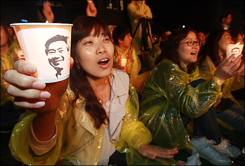 21일 오후 서울광장에서 열린 '파워 투 더 피플(Power To The People) 2011' 추모콘서트에서 시민들이 노 전 대통령의 얼굴이 그려진 촛불을 들어보이며 공연을 즐기고 있다.