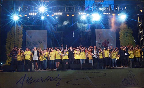21일 오후 서울광장에서 열린 '파워 투 더 피플(Power To The People) 2011' 추모콘서트에서 노래패 '우리나라'와 자원봉사자들이 무대에 올라와 노래 'Power To The People'를 합창하고 있다.