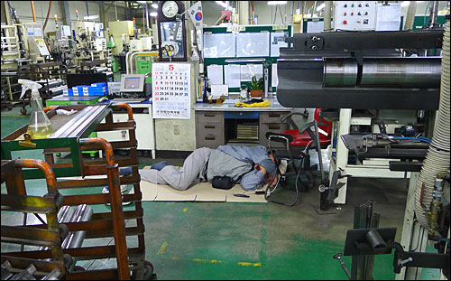 2011년 5월 24일 충남 아산시 소재 유성기업에서 한 조합원이 공장 바닥에 종이박스를 깔고 한뎃잠을 자고 있다.