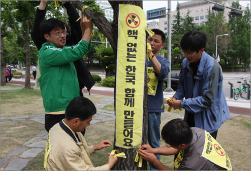 진보신당 대전시당과 충남도당 당원들이 '반핵도보대행진' 출발에 앞서 나무에 노란리본을 묶는 퍼포먼스를 펼치고 있다.