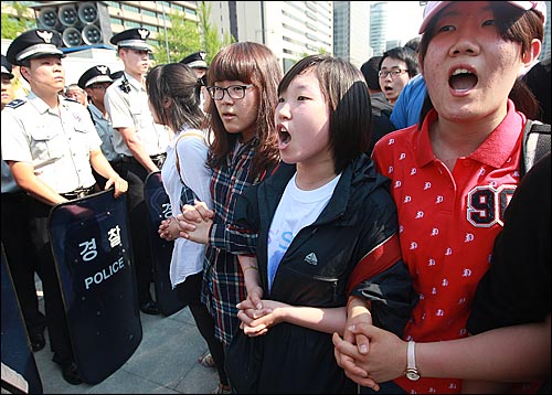 29일 오후 서울 광화문 광장에서 반값등록금과 청년실업 해결을 요구하며 시위를 벌이던 대학생들이 청와대로 행진을 시도하다가, 경찰들에게 강제연행되자 스크럼을 짜고 구호를 외치고 있다.