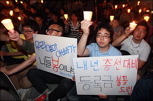 2일 오후 서울 종로구 광화문광장 앞에서 열린 촛불집회에 참석한 대학생들이 반값등록금과 청년실업 해결을 촉구하며 촛불을 들어보이고 있다.