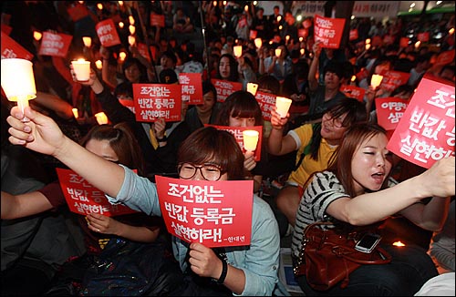 2일 오후 서울 종로구 광화문광장 앞에서 열린 촛불집회에 참석한 대학생들이 '반값등록금과 청년실업 해결'을 촉구하며 촛불과 손피켓을 들어보이고 있다.