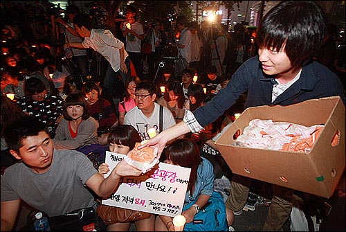 2일 오후 서울 종로구 광화문광장 앞에서 열린 촛불집회에서 한 학생이 일반 시민들로부터 격려의 뜻으로 지원 받은 만두와 피자 등의 음식물을 학생들에게 나눠주고 있다.