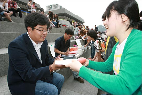 문화평론가 진중권씨와 카이스트 정재승 교수가 대학생들이 가져 온 책에 사인을 해주고 있다.