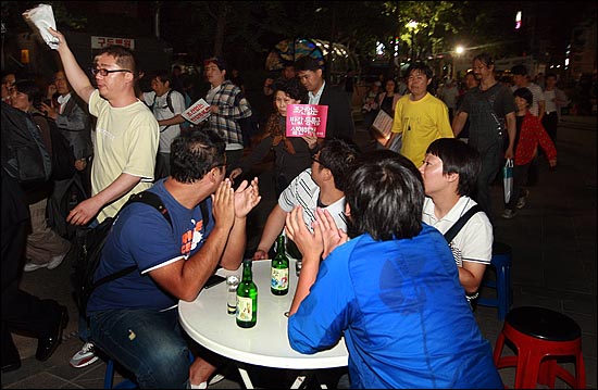 반값등록금 실현을 위한 촛불집회를 마친 대학생들과 시민들이 7일 오후 서울 중구 무교동 음식문화특화거리 골목에서 거리행진을 벌이자, 회식을 하던 시민들이 학생들을 격려하며 박수를 보내고 있다.