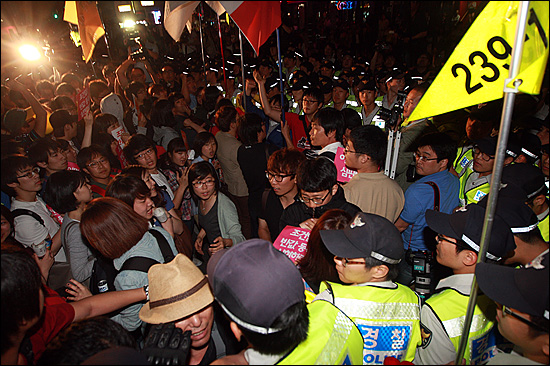 반값등록금 실현을 위한 촛불집회를 마친 대학생들과 시민들이 7일 오후 서울 청계광장 인근 서울파이낸셜센터 뒤편에서 반값등록금 실현을 요구하며 행진을 벌이다가 경찰들에게 저지돼 대치를 벌이고 있다.