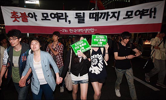  반값등록금 촛불문화제를 마친 대학생들과 시민들이 10일 오후 서울 중구 을지로입구역 앞에서 '촛불아 모여라, 될 때까지 모여라!'라고 적힌 대형현수막을 펼쳐보이며 거리행진을 벌이고 있다.