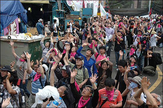 2011년 6월 12일 1차 희망버스. 참가자들이 13시간 가량 부산 한진중공업 영도조선소 85호 크레인 아래에서 머문 뒤 떠나면서 손을 흔들어 인사하고 있다.