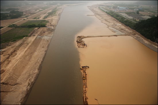 강창교 하류. 강은 직선화되었고 포크레인에 의한 직접준설이 이루어지고 있다. 심각한 탁도가 유발되고 있다.
