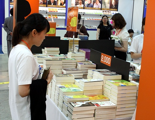 베르나르 베르베르의 번역본이 출간되는 '열린책들' 부스 전시장에 책 가격이 2000원이라는 표기를 보고 있는 관객