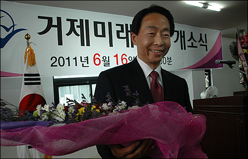 거제미래포럼 김현철 대표가 제19대 총선 출마를 선언했다. 사진은 김현철 대표가 2011년 6월 16일 거제미래연구소 개소식 때 꽃다발을 받고 환하게 웃고 있는 모습.