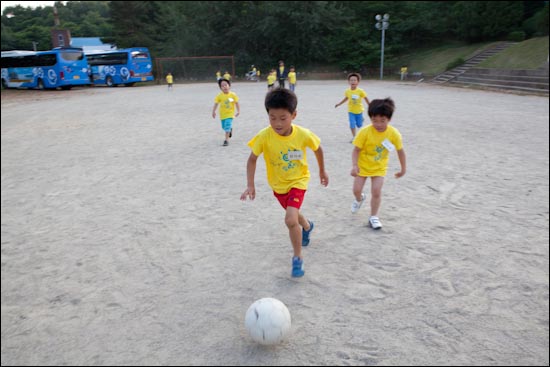 '오마이스쿨' 도착한 기수(영덕 창수초 인천분교)와 아이들이 운동장에서 어울려 공을 차고 있다.
