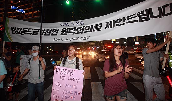  대학생들과 시민들이 17일 오후 서울광장 앞 도로를 점거한 채, '반값등록금 1천인 원탁회의를 제안드립니다'라고 적힌 대형 현수막을 들어보이며 거리행진을 벌이고 있다.