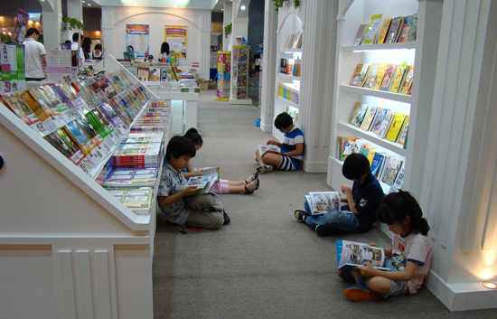 바닥에 앉아 책을 읽는 아이들